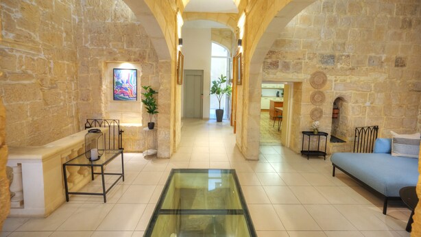 A spacious lobby with stone walls, a glass coffee table, and a blue sofa. - Magestic palazzo, jacuzzi on roof terrace GOVAL-3 (Valletta)