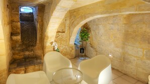 A spacious interior with stone walls, a glass ceiling, and modern white furniture. - Magestic palazzo, jacuzzi on roof terrace GOVAL-3 (Valletta)