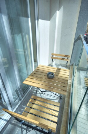 Een houten bank met een band, geplaatst voor een glazen wand met een metalen frame.