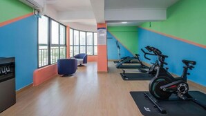 A gym with exercise bikes, a seating area, and a large window. - Vienna Hotel Shenzhen Fuyong Xintian (Shenzhen)