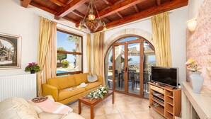 A cozy living room with a sofa, TV, and a view of the outdoors.