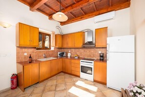 A kitchen with wooden cabinets, a sink, a microwave, an oven, and a refrigerator.