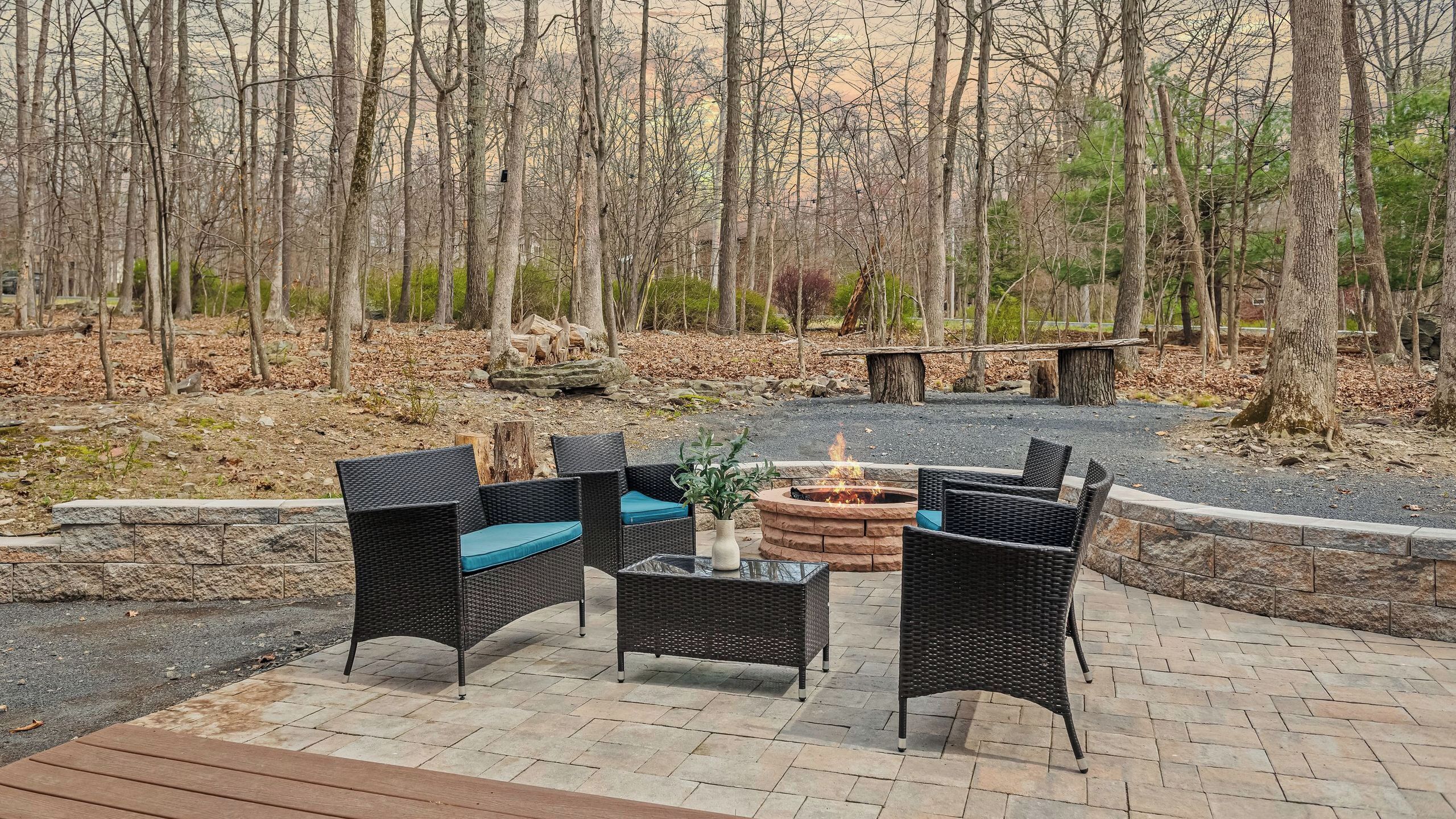 An outdoor seating area with wicker furniture and a fire pit.