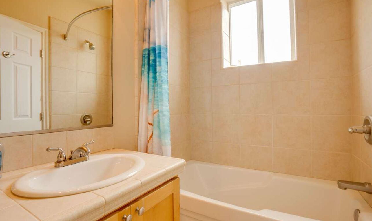 Un ba ño con lavabo, espejo, ducha y bañera.