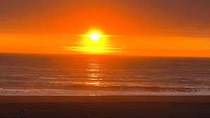 Un coucher de soleil sur l’océan, avec un ciel dégagé.
