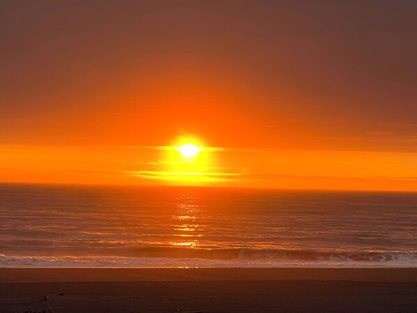 Un atardecer sobre el océano bajo un cielo despejado.