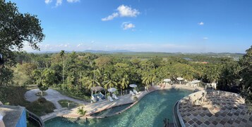 Una piscina al aire libre, sombrillas, sillones reclinables de piscina