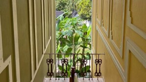 A narrow corridor with a view of lush greenery and distant hills.