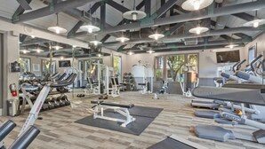 Et fitnesscenter med løbebånd, styrkemaskiner og håndvægte.
