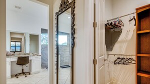 A modern bathroom with a large mirror, a shower area, and a wooden vanity.
