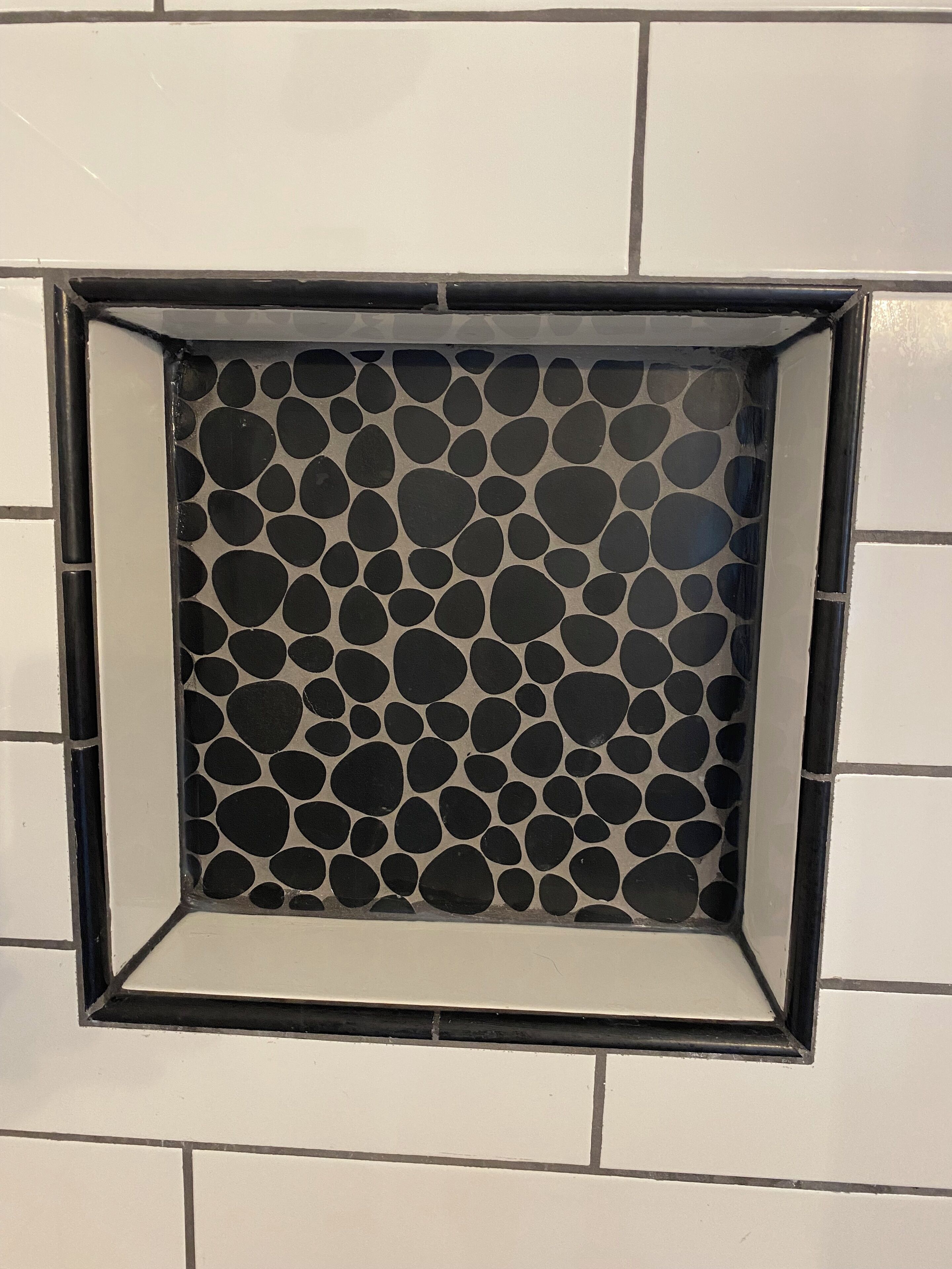 A square vent with a circular pattern.