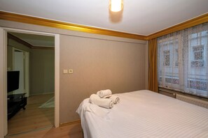 A bedroom with a bed, a TV, and a window with curtains. - La Vitinre (Istanbul)