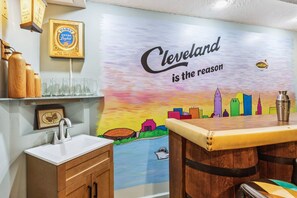 Un espace bar agrémenté d’une fresque représentant le profil d’une ville et du texte suivant : « Cleveland, c’est ce qui compte. »