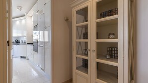 A modern kitchen with white cabinets and a built-in oven.