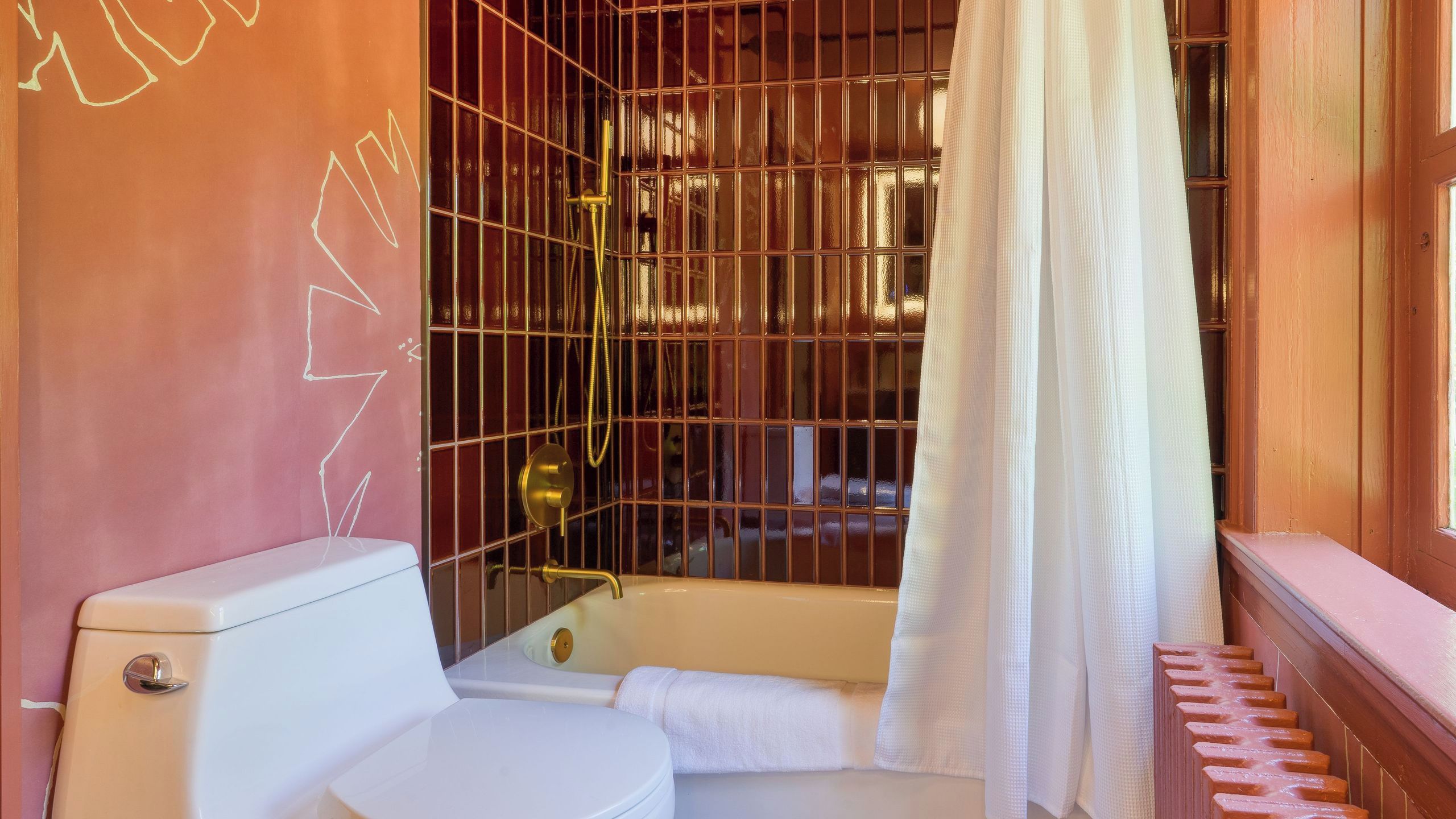 A bathroom with a toilet, bathtub, and shower enclosure.