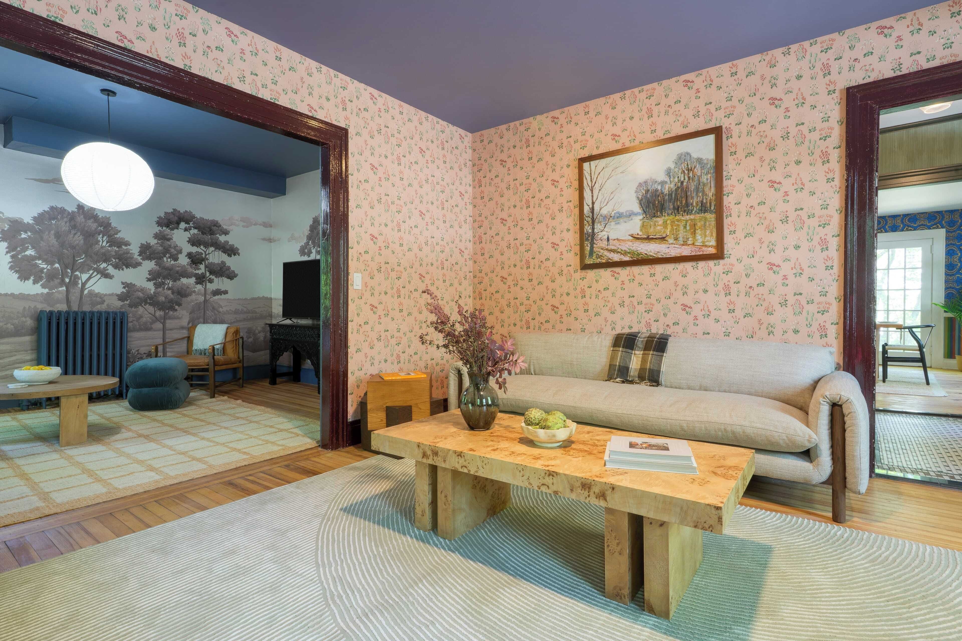 Un salon avec un canapé, une table basse et un tableau accroché au mur.