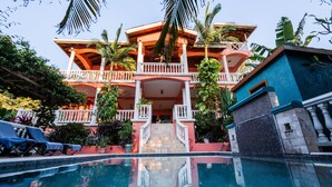 Un grand immeuble à plusieurs étages, avec une piscine en premier plan.