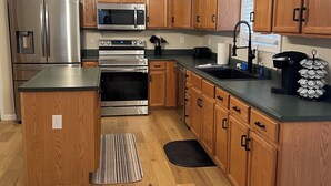 Une cuisine moderne avec des meubles en bois, des appareils électroménagers en acier inoxydable et un îlot central.