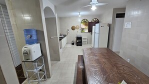 Una cocina compacta con dispensador de agua, estufa y refrigerador.
