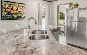 A kitchen with a marble countertop, stainless steel sink, and a refrigerator. - Southgate: 800 Yards to Campus/Kyle Field (College Station)
