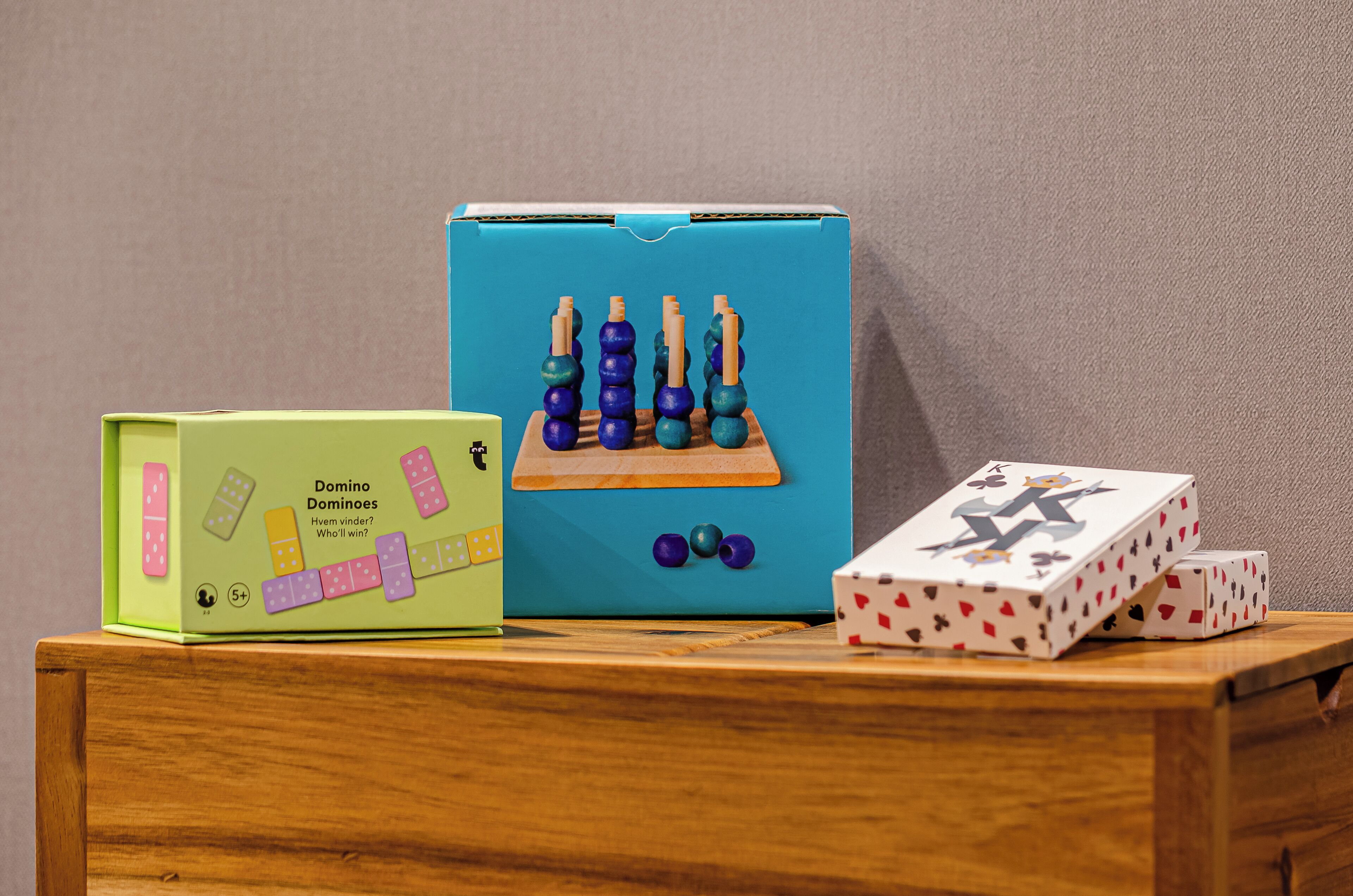 A wooden chest with a green box labeled "Dominoes" and a blue box with wooden dominoes.