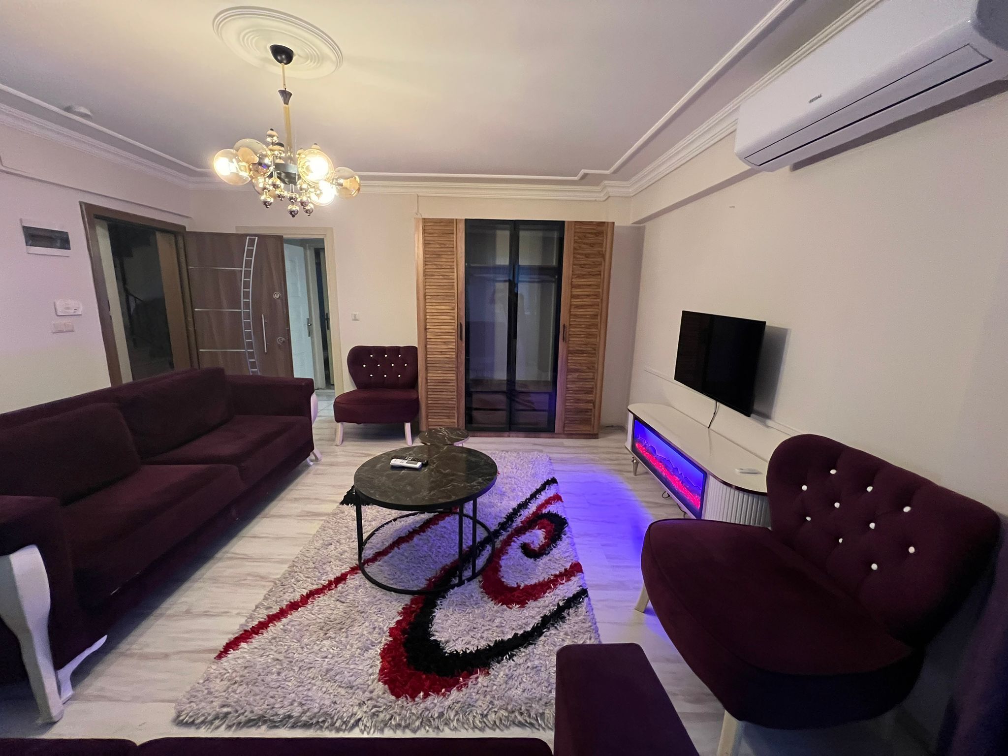 Una sala de estar moderna con sofá, sillón y televisor.