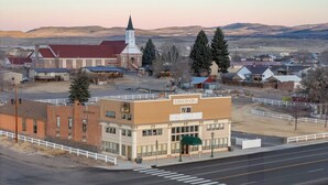 A building with a sign reading "ROAD CREEK INN" and a church with a steeple in the background.