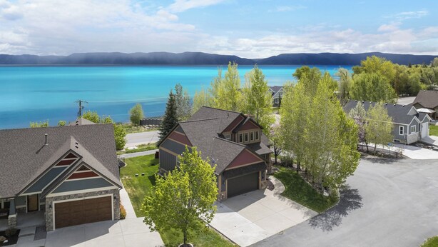 A residential area with houses, a driveway, and a lake. - Lakeside Haven, a cozy and relaxing home that sleeps 24 with pool/hottub access! (Garden City)
