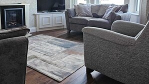 Una sala de estar con chimenea, televisor y sofá.