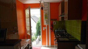 Une cuisine avec une grande fenêtre, une cuisinière et un réfrigérateur.