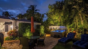 A patio with a hot tub, lounge chairs, and a table with chairs. - 2 Side-by-Side Delray Beach Homes & Guest House - 1 blk to beach & Atlantic Ave! (Delray Beach)