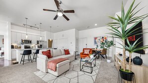 Ein modernes Wohnzimmer mit einem weißen Sofa, einem Couchtisch und einem Deckenventilator.