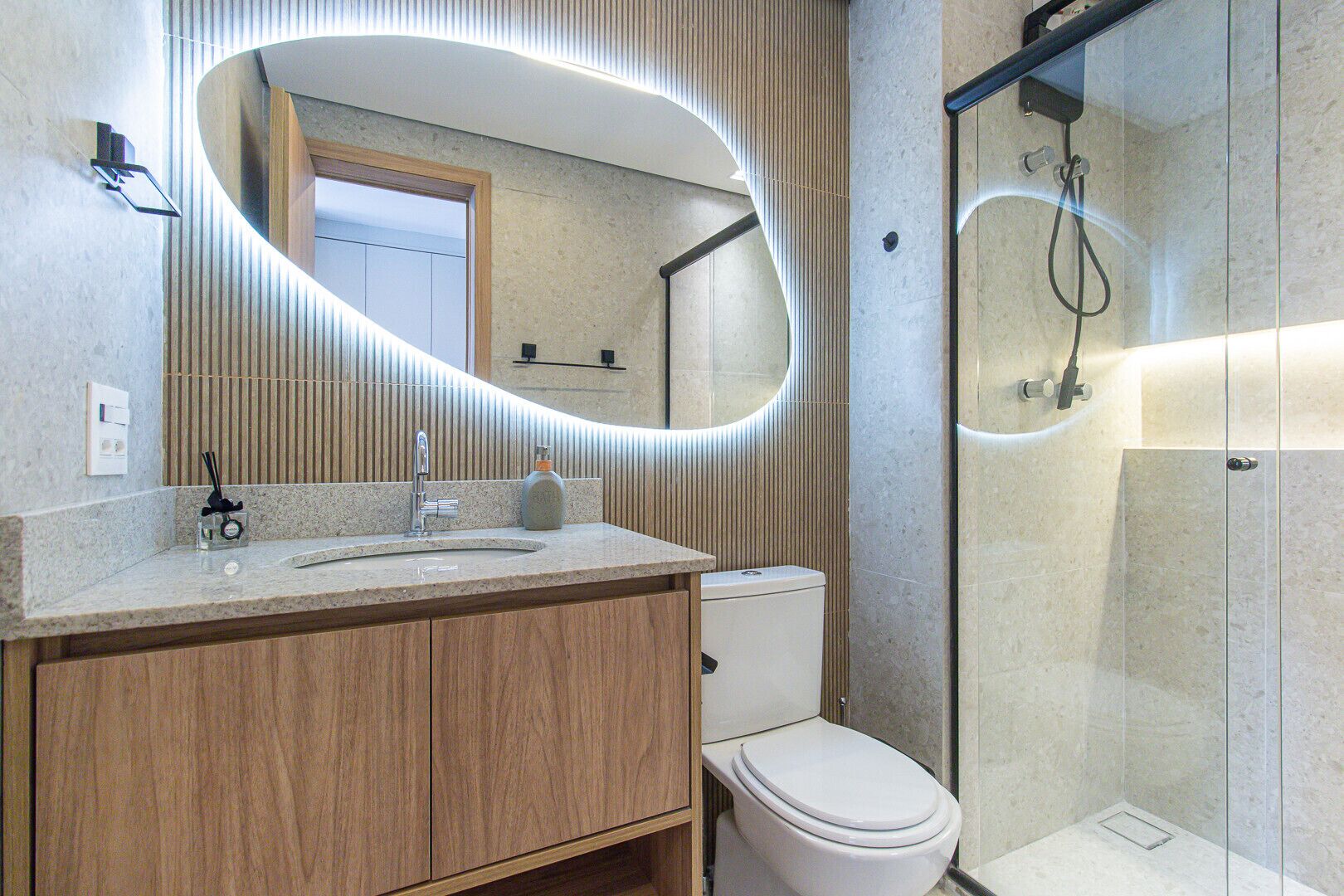 Une salle de bain moderne avec un meuble-lavabo, des toilettes et une douche à l’italienne.