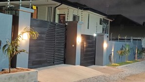 Une maison moderne dotée d’un grand garage, d’un escalier et d’une entrée bien éclairée.