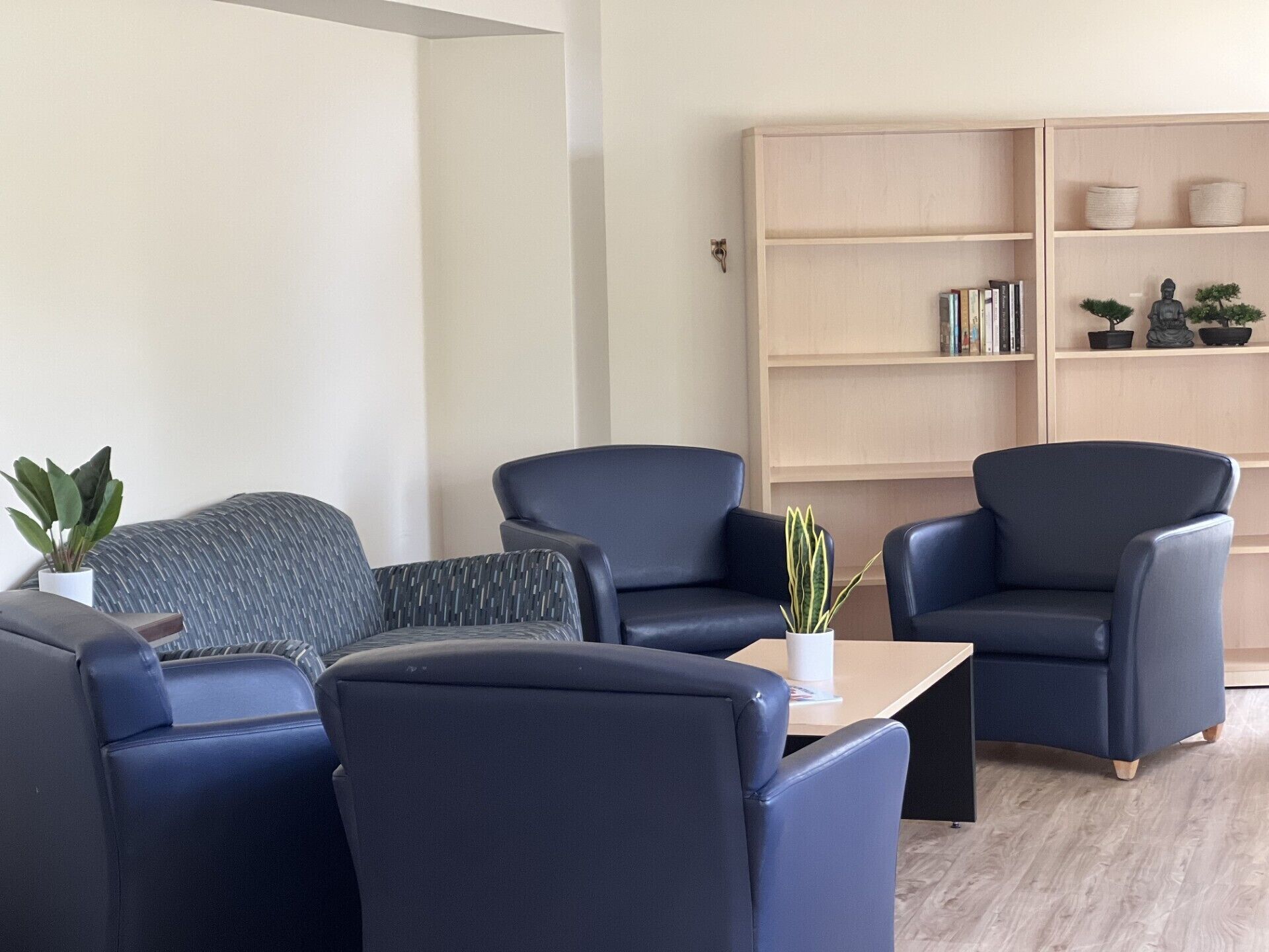 Una sala moderna con un conjunto de sofás, una mesa de centro y una estantería.