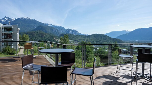 Una terrassa amb seients exteriors, amb vista a un paisatge de muntanya.