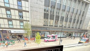 A view from a window overlooking a Marks & Spencer store and a pink food truck outside. - City Centre 1Bed Flat (Sheffield)