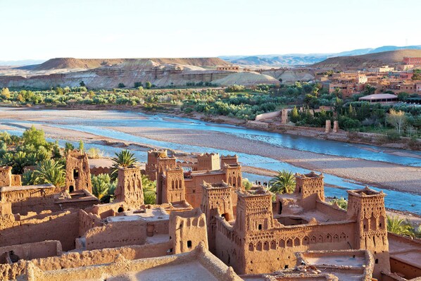 A desert landscape with traditional mud-brick buildings and a river. - Family Stay Ouarzazate (Ouarzazate)