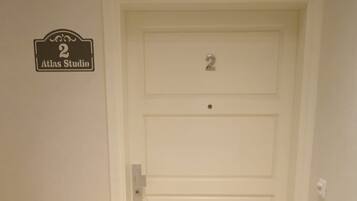 Una puerta blanca con el número 2 y un cartel que dice 'Atlas Studio'.
