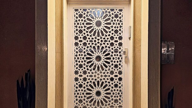 A door with intricate geometric patterns and a small step leading up to it. - Family Stay Ouarzazate (Ouarzazate)