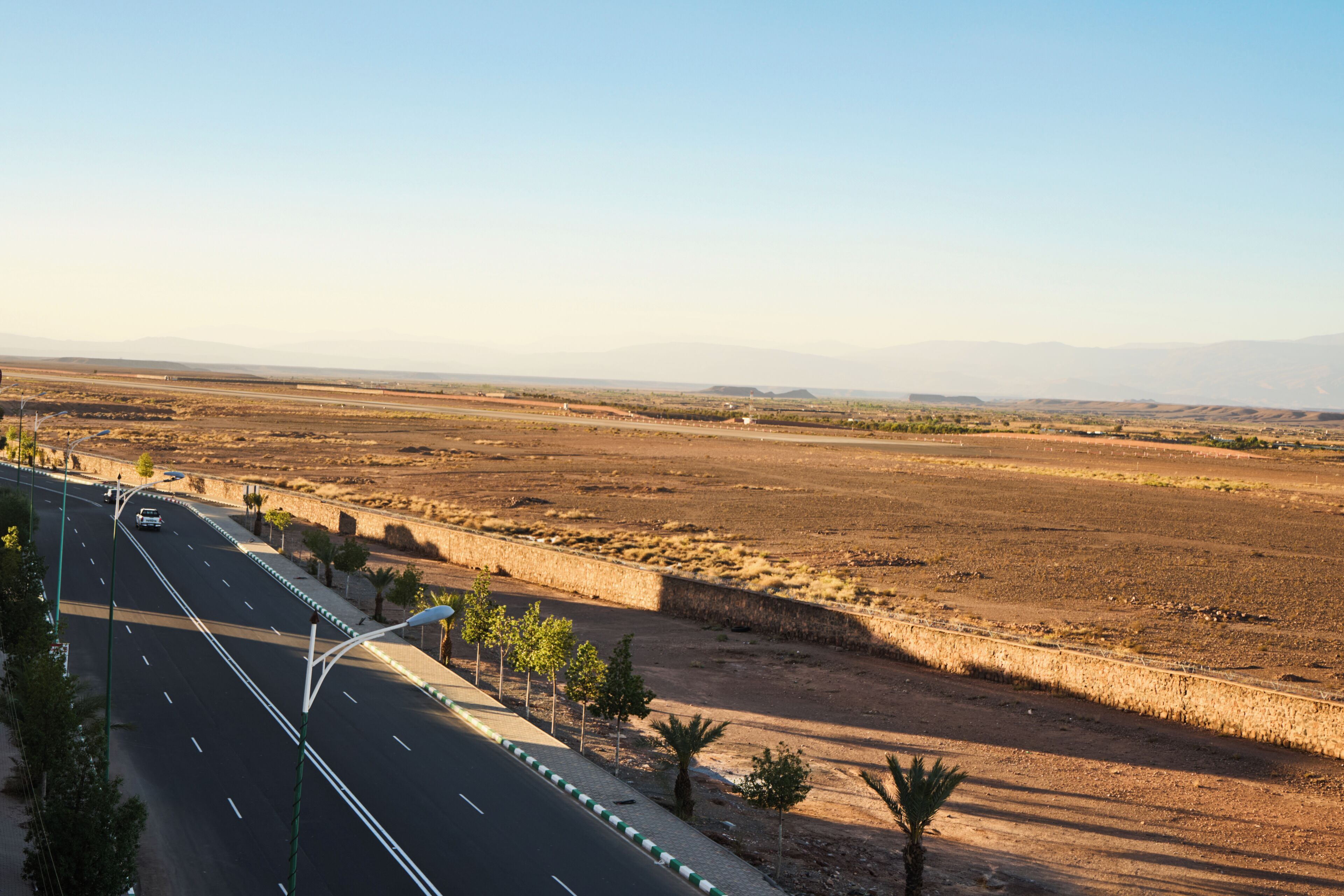 A highway with a clear road, guardrails, and sparse vegetation.