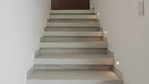 A staircase with white steps and a wooden wall at the top.