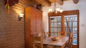Ein rustikaler Essbereich mit Holztisch, Stühlen und einem Holzschrank.