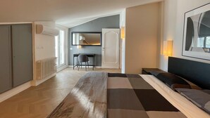 Une chambre d’hôtel moderne avec un grand lit, un bureau et une chaise.