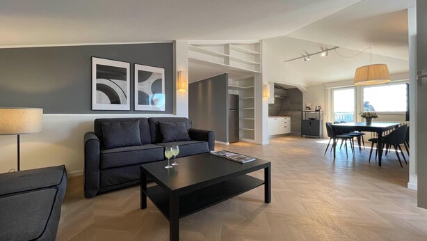 Un salon moderne avec un canapé, une table basse et un coin repas.