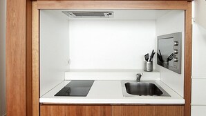 A compact kitchen with two sinks, a stainless steel range hood, and a utensil holder. - Desuite Bolsena Loft (Milan)
