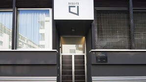 A modern hotel entrance with a glass door, a sign reading "DESUITE," and a plaque indicating it's a "PPHOTELS" property. - Desuite Bolsena Loft (Milan)
