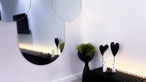 A modern room with a large mirror, a potted plant, and decorative heart-shaped objects on a black console. - 2bedroom luxury apt 24hrs light/wifi in lekki (Lekki)