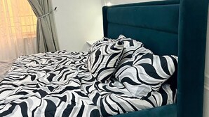 A bed with a zebra-patterned bedspread and a teal upholstered headboard. - 2bedroom luxury apt 24hrs light/wifi in lekki (Lekki)