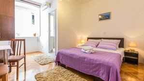 A bedroom with a bed, bedside lamps, a chair, a small table, and a window with a view. - Secret & Stylish Hideaway Apartments Zadar- 2 Room (Zadar)